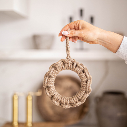 Luxe B Co jute kitchen trivet with woven texture, heat-resistant surface, designed to protect countertops from hot cookware.