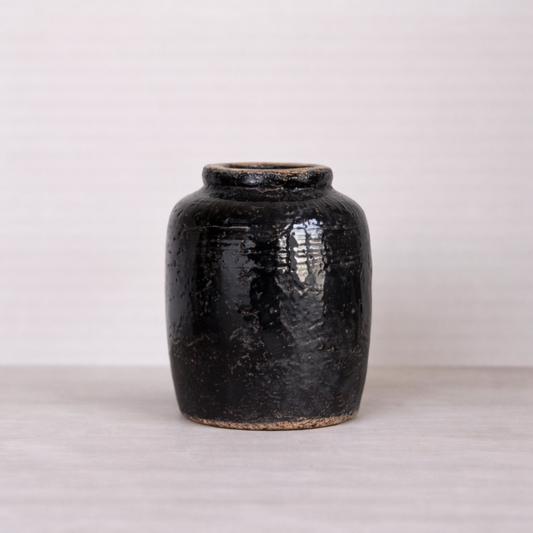 Black ceramic jar on a light gray background