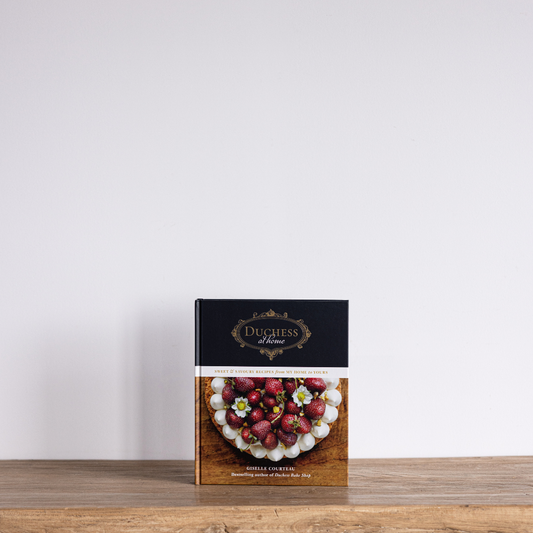 Duchess At Home Cookbook by Luxe B Co featuring recipes and culinary tips, displayed with open pages and colorful food images.