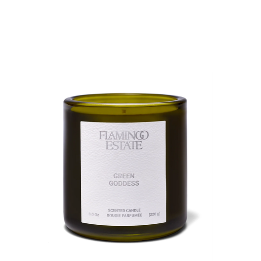 Green Goddess candle by Luxe B Co with a green glass jar and a lit wick, emitting a warm glow and natural aroma.