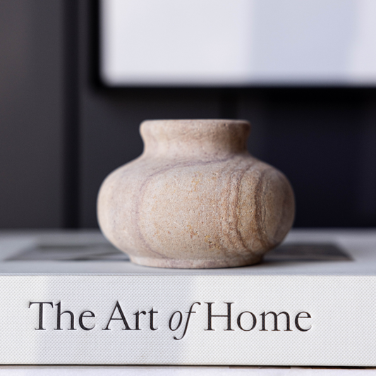 Hand-carved sandstone bud vase by Luxe B Co featuring a textured, natural stone finish and a narrow opening for floral arrangements.