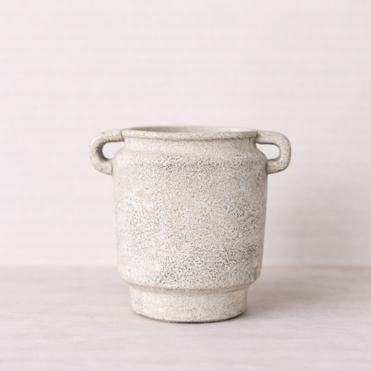 Speckled gray ceramic planter with handles on a light background