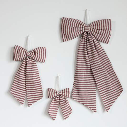Striped cranberry red fabric bows by Luxe B Co, oversized decorative bows made from vibrant red and white striped fabric.