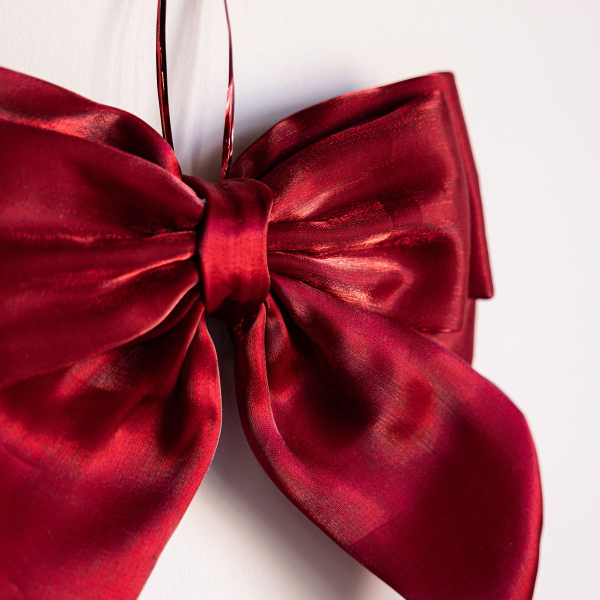 Red gauze bow with bold design from Luxe B Co, featuring soft, lightweight fabric and a prominent, stylish bow shape.