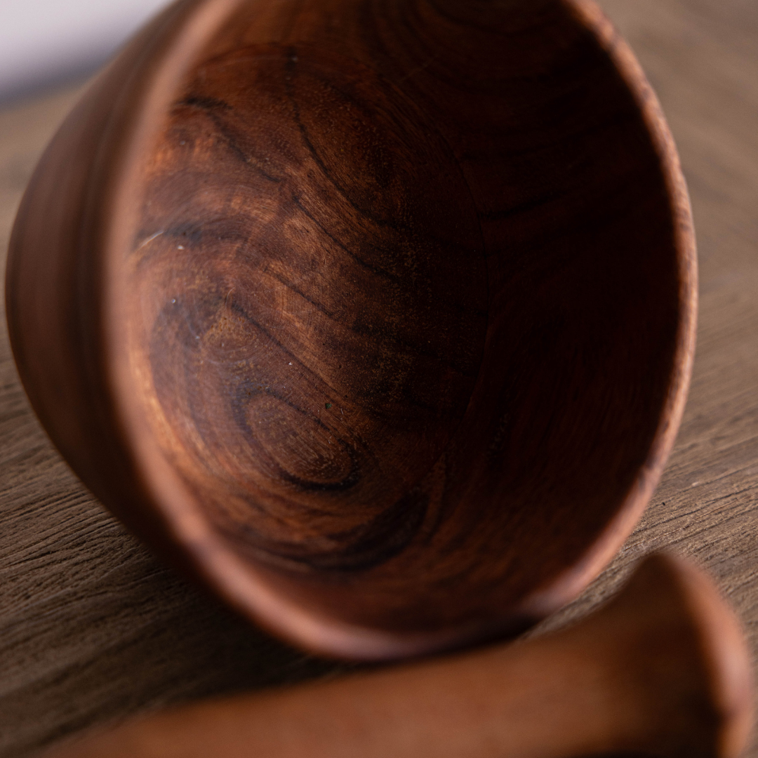 Luxe B Co wooden mortar and pestle set for grinding herbs and spices on a kitchen countertop.