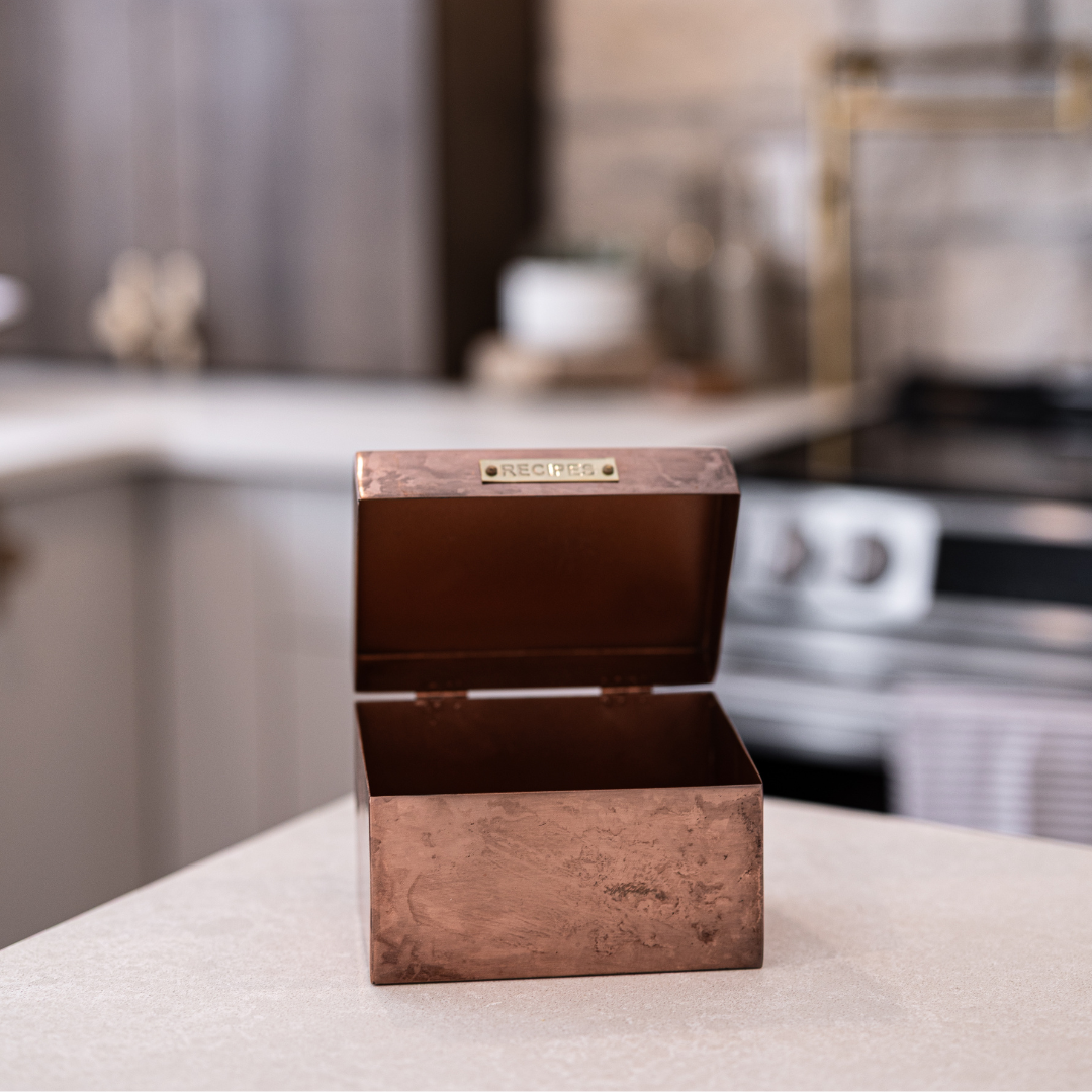 Luxe B Co. copper recipe box with a polished metal finish, featuring a lid and decorative details for stylish home decor storage.