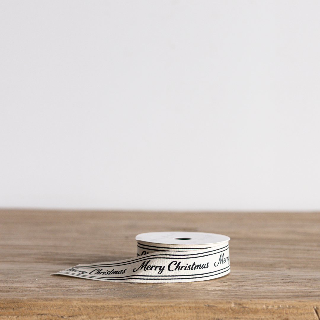 Black cursive writing Merry Christmas ribbon by Luxe B Co Wholesale, with festive holiday design and elegant script.