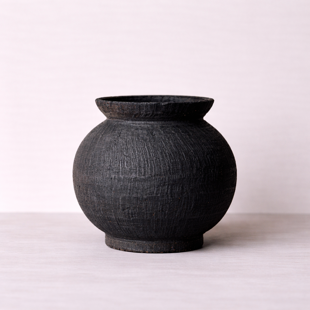 Black textured vase on a white background