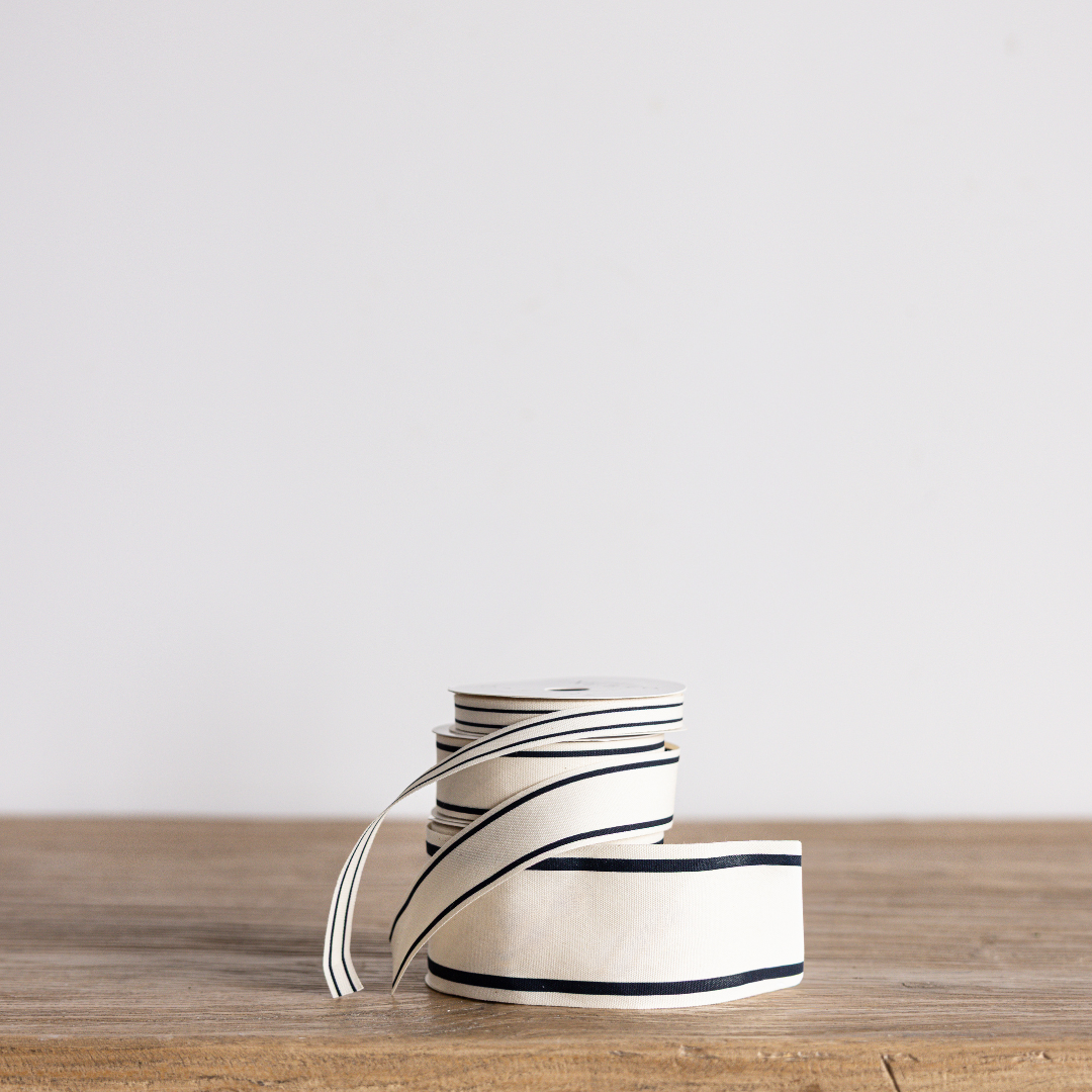 Black stripe woven ribbon by Luxe B Co Wholesale, showing textured fabric with bold black and white stripe pattern.