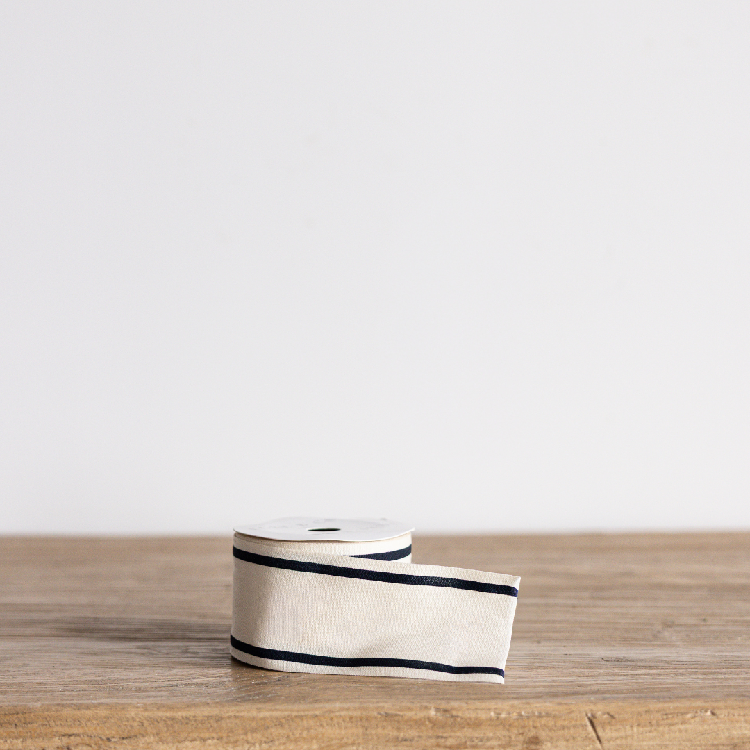 Black stripe woven ribbon by Luxe B Co Wholesale, showcasing textured fabric with alternating black and subtle stripe pattern.