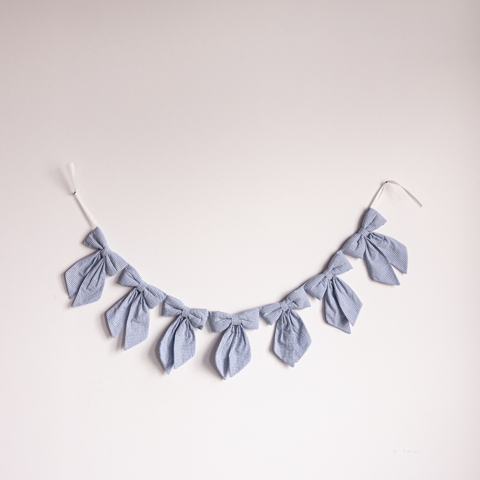 Blue mini gingham fabric bow garland by Luxe B Co, featuring small blue and white checkered fabric bows for decoration.