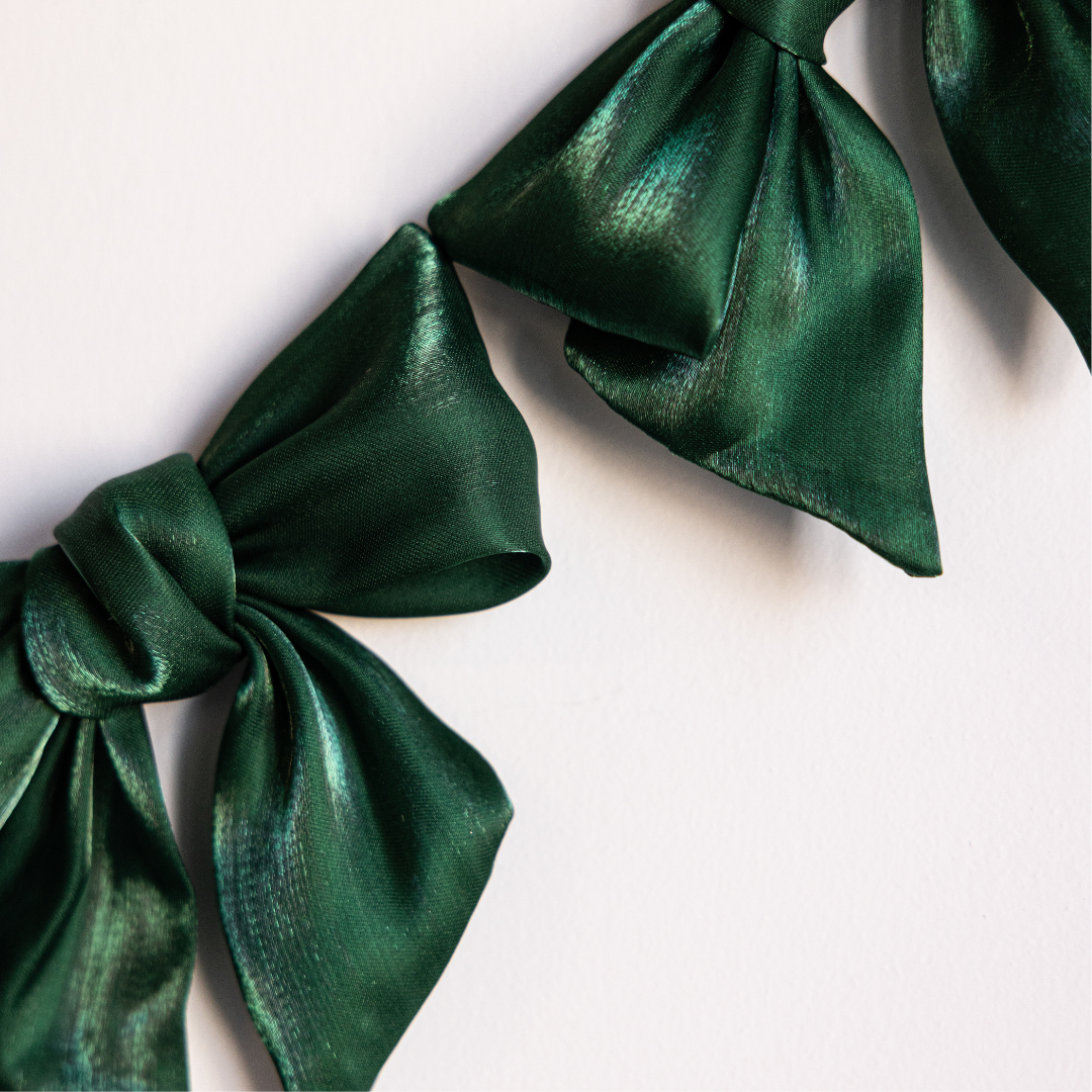 Emerald green gauze bow garland with soft, flowing bows from Luxe B Co, perfect for festive or decorative occasions.