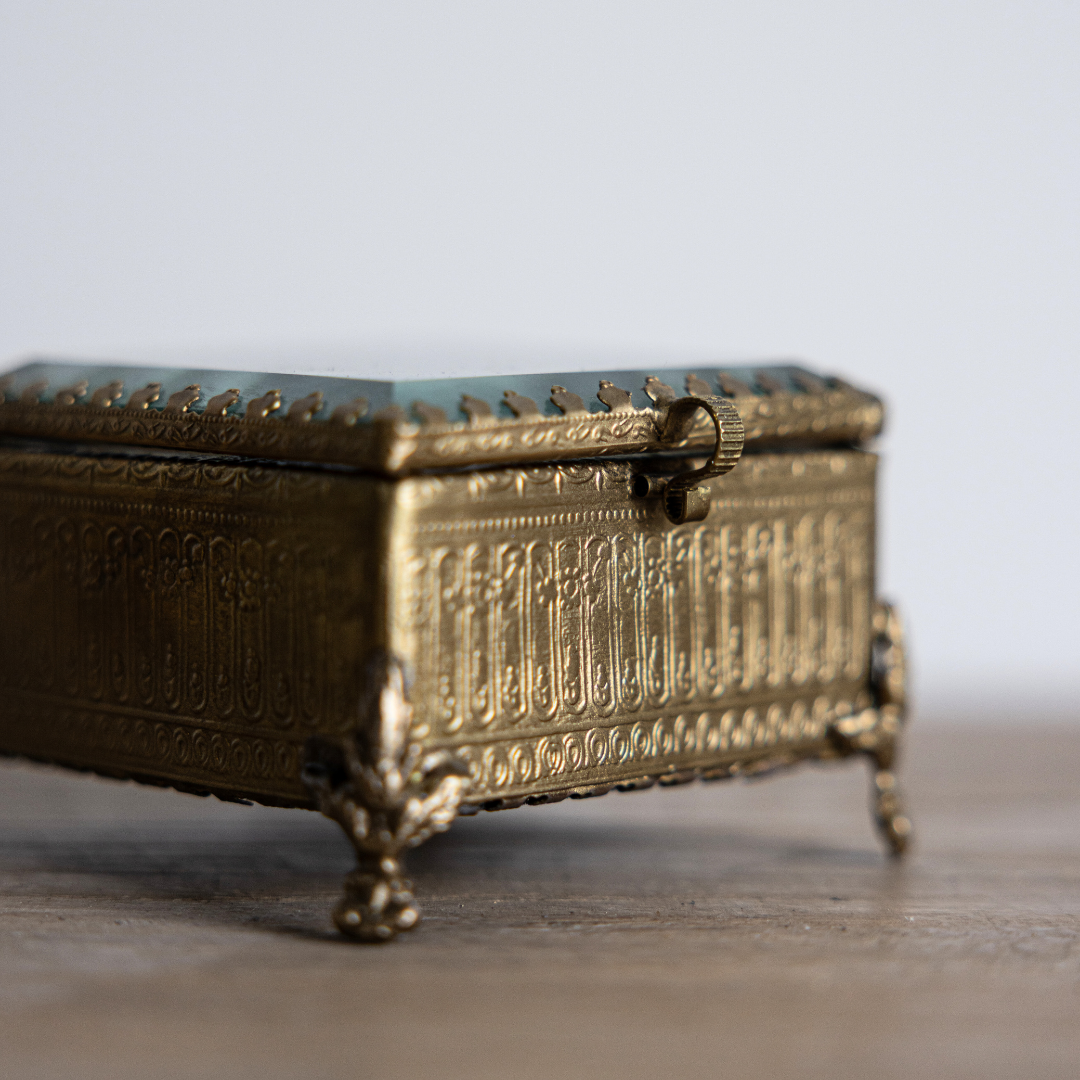Decorative brass and glass box with footed bevelled edges by Luxe B Co, featuring a sleek, modern design.