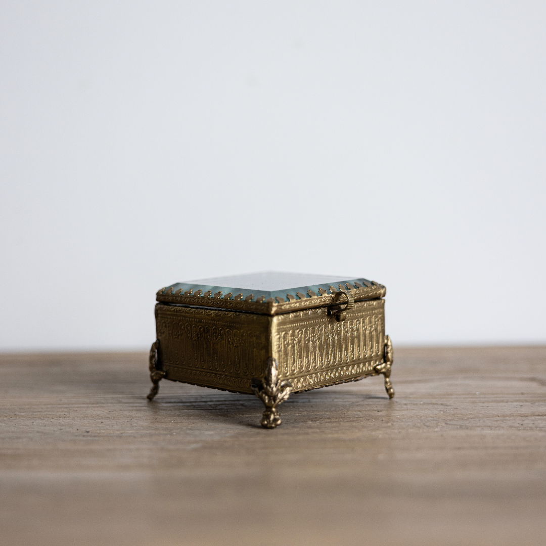 Decorative footed brass and glass box with beveled edges, designed by Luxe B Co for elegant home decor.
