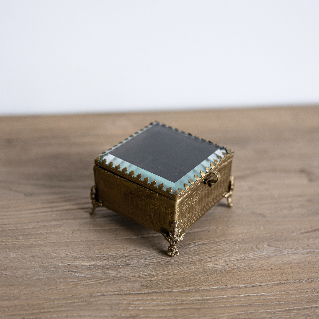 Decorative footed brass and glass box with beveled edges, designed by Luxe B Co for elegant home decor and display.