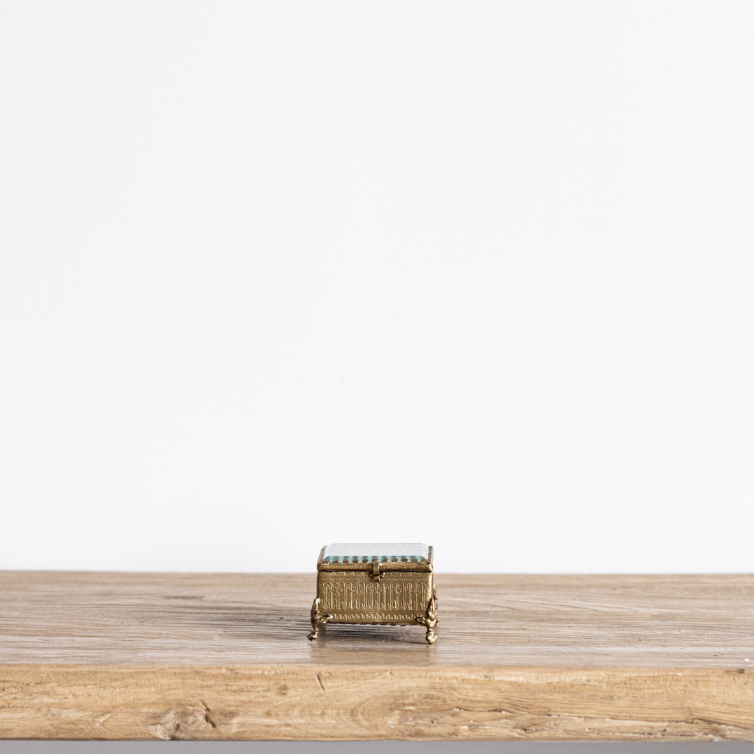 Decorative brass and glass box with footed design by Luxe B Co, featuring beveled edges for elegant display.