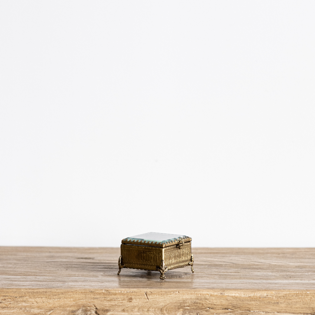 Decorative footed brass and glass box with beveled edges, designed by Luxe B Co for elegant storage or display.