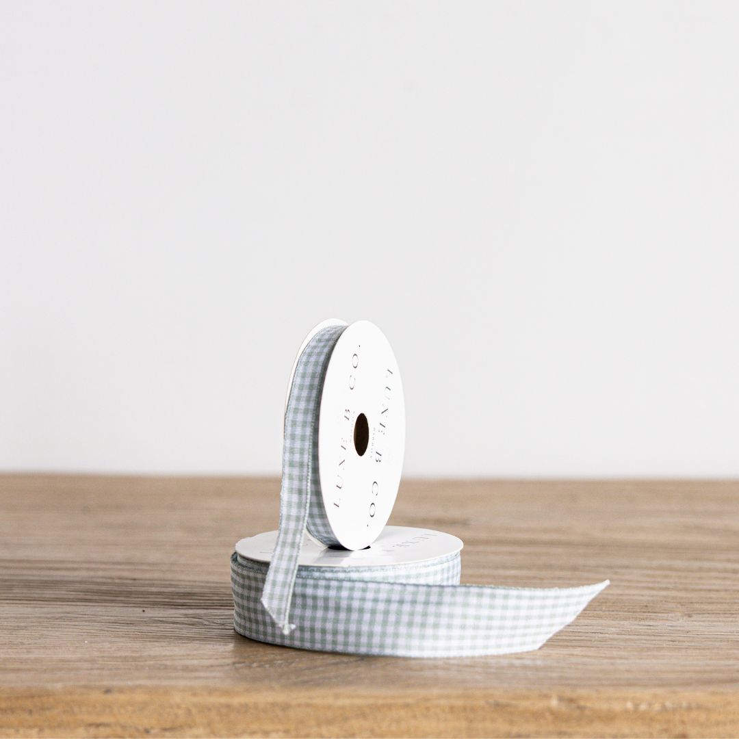 Seafoam blue gingham ribbon by Luxe B Co, featuring a classic checkered pattern, perfect for crafts and gift wrapping.