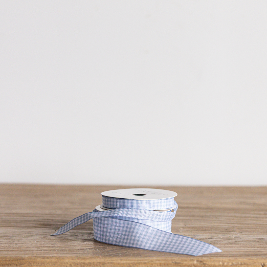 Sky blue gingham ribbon by Luxe B Co, showcasing a soft fabric with a classic checked pattern perfect for crafts and decorations.