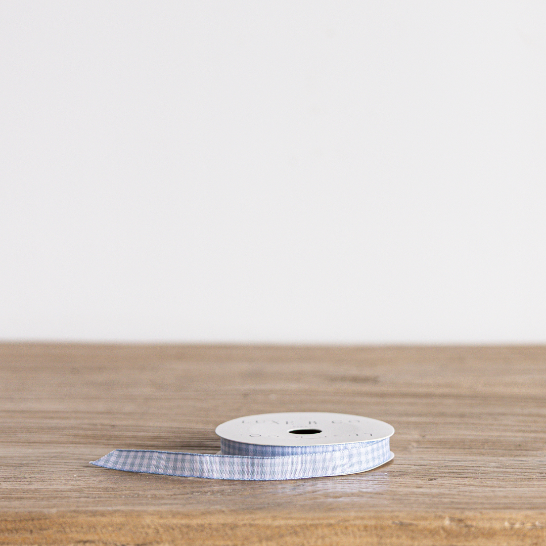 Sky blue gingham ribbon by Luxe B Co, featuring a classic checkered pattern, ideal for crafts and gift wrapping.