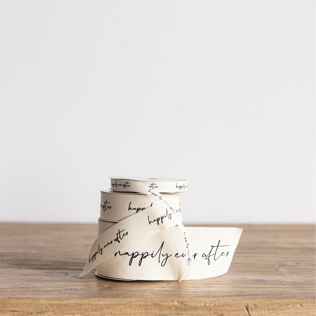 Cream-colored "Happily Ever After" cursive writing ribbon from Luxe B Co Wholesale, featuring elegant script design.