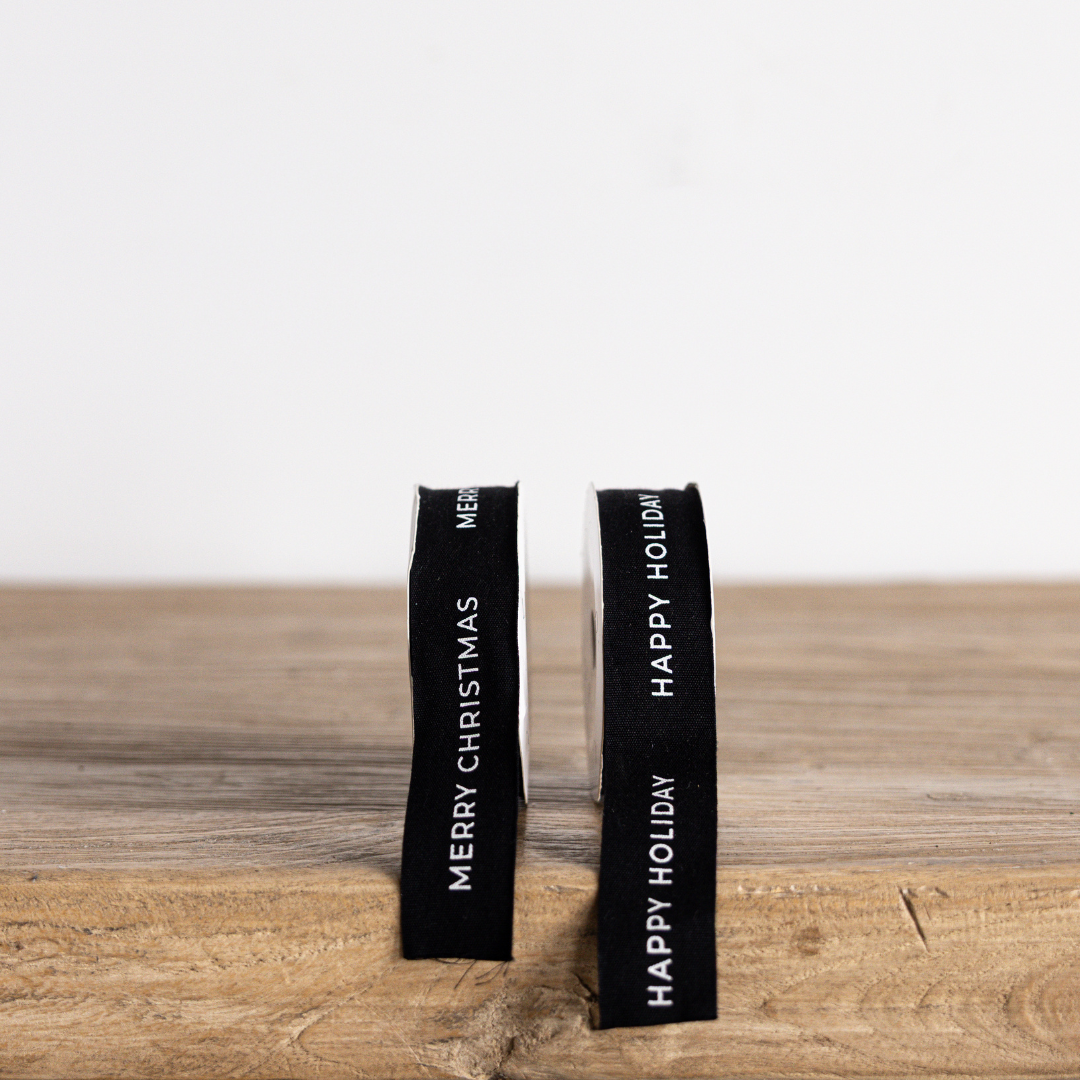 Black holiday ribbon with "Happy Holiday" text from Luxe B Co, featuring festive design and satin finish.