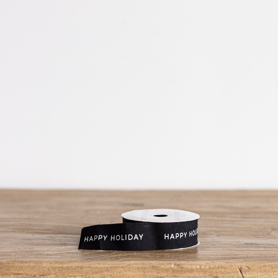 Black holiday ribbon by Luxe B Co with festive "Happy Holiday" message, perfect for Christmas gift wrapping and decorations.