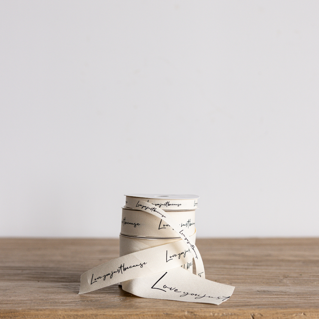 Cursive writing ribbon with "Love You Just Because" message, white background, by Luxe B Co Wholesale, decorative craft ribbon.