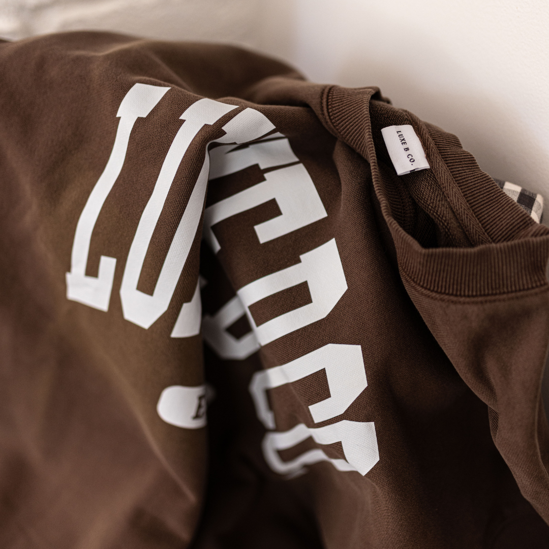 Brown Luxe B Co. pullover sweater with a cozy fit, featuring a classic round neckline and soft knit texture.