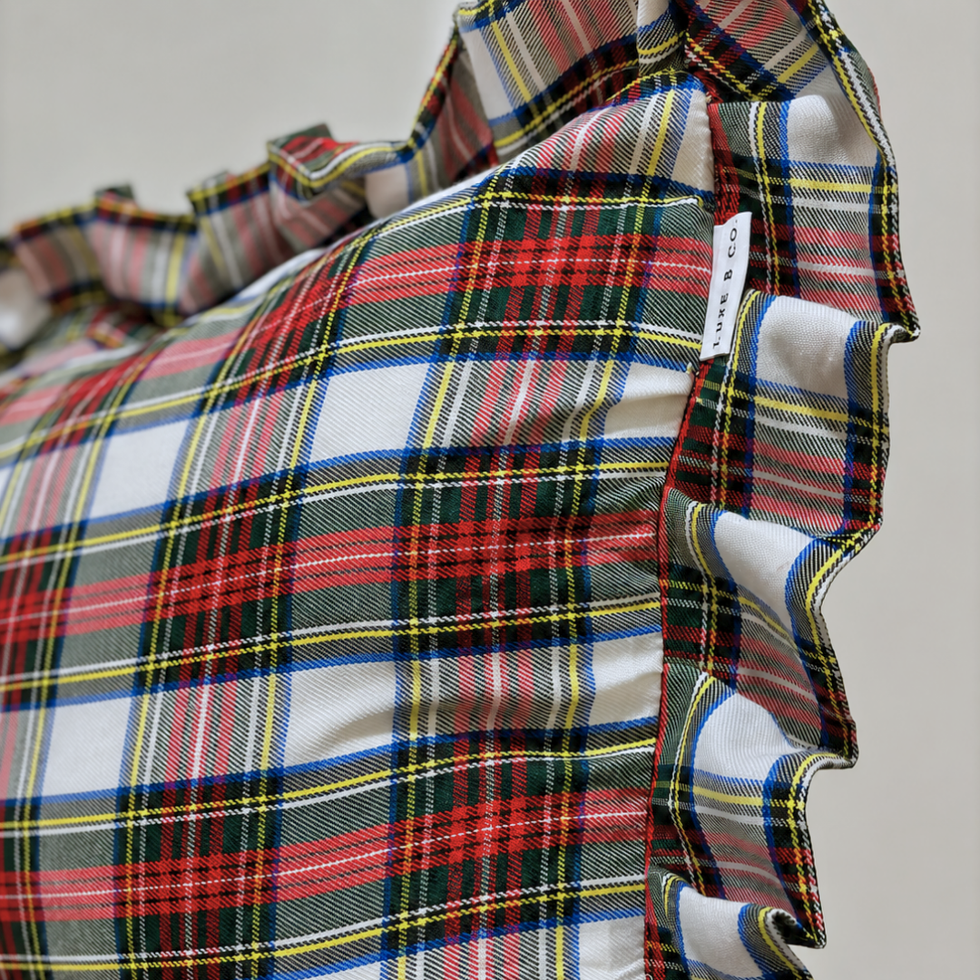 Luxe B Co holiday plaid ruffle bolster pillow cover featuring festive red and green plaid fabric with ruffled edges.