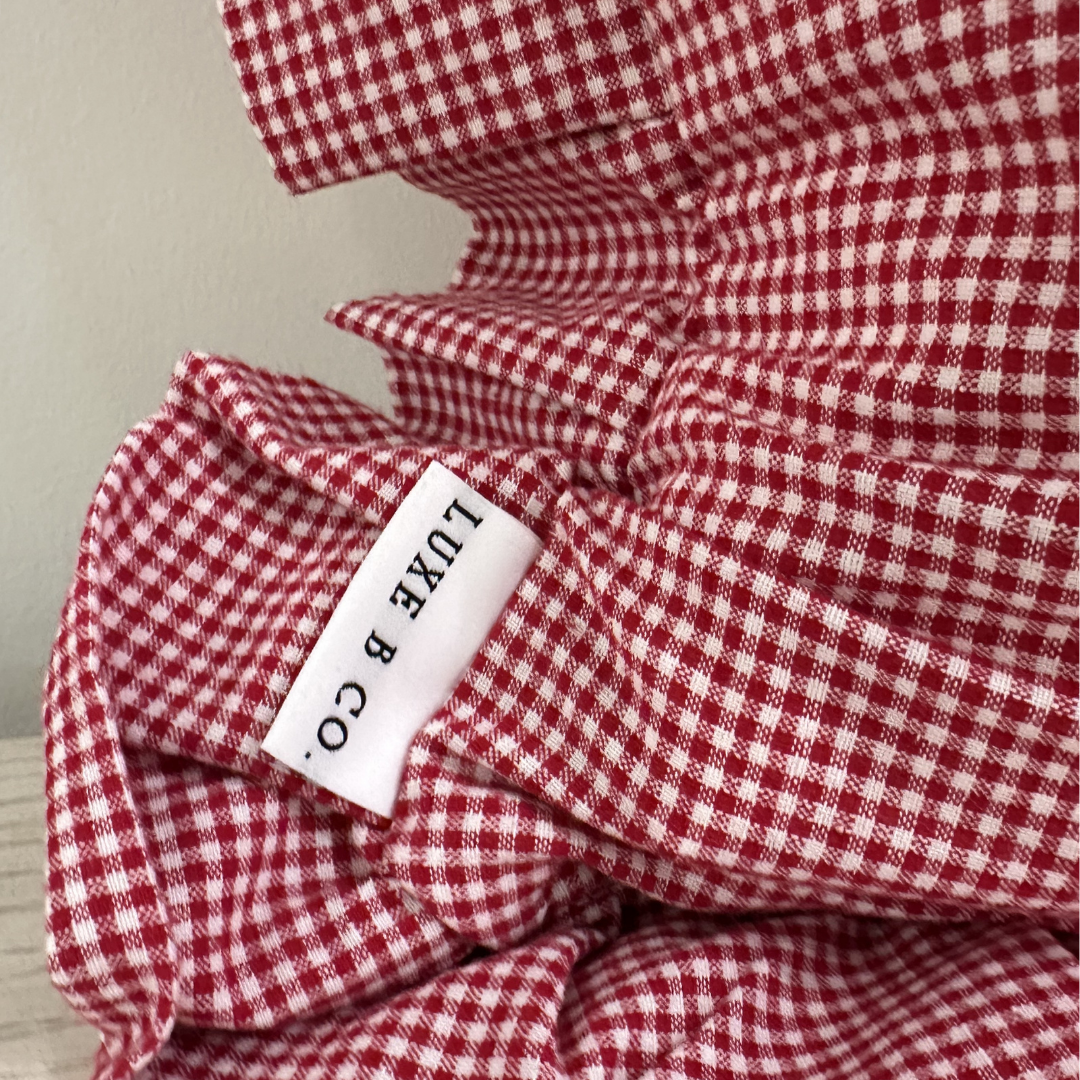 Red mini gingham ruffle lumbar pillow sham by Luxe B Co, featuring a soft fabric and decorative ruffle detail.
