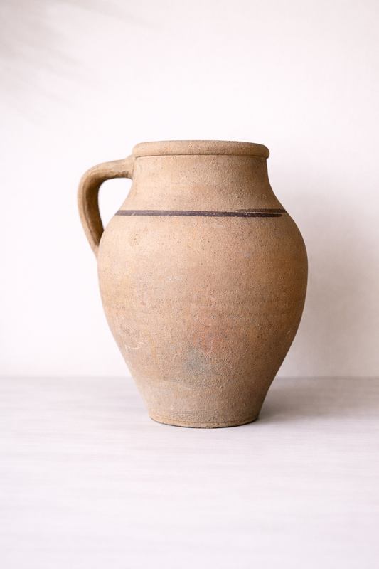 Brown ceramic pitcher on a white background