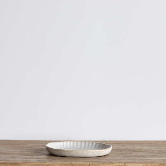 White textured ceramic platter by Luxe B Co, showing a flat, round serving platter with a detailed surface finish.