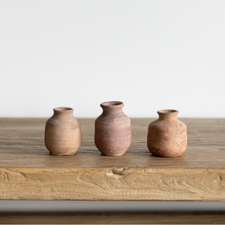 Mini terracotta clay bud vase by Luxe B Co with a simple, rounded design and narrow opening for small floral arrangements.