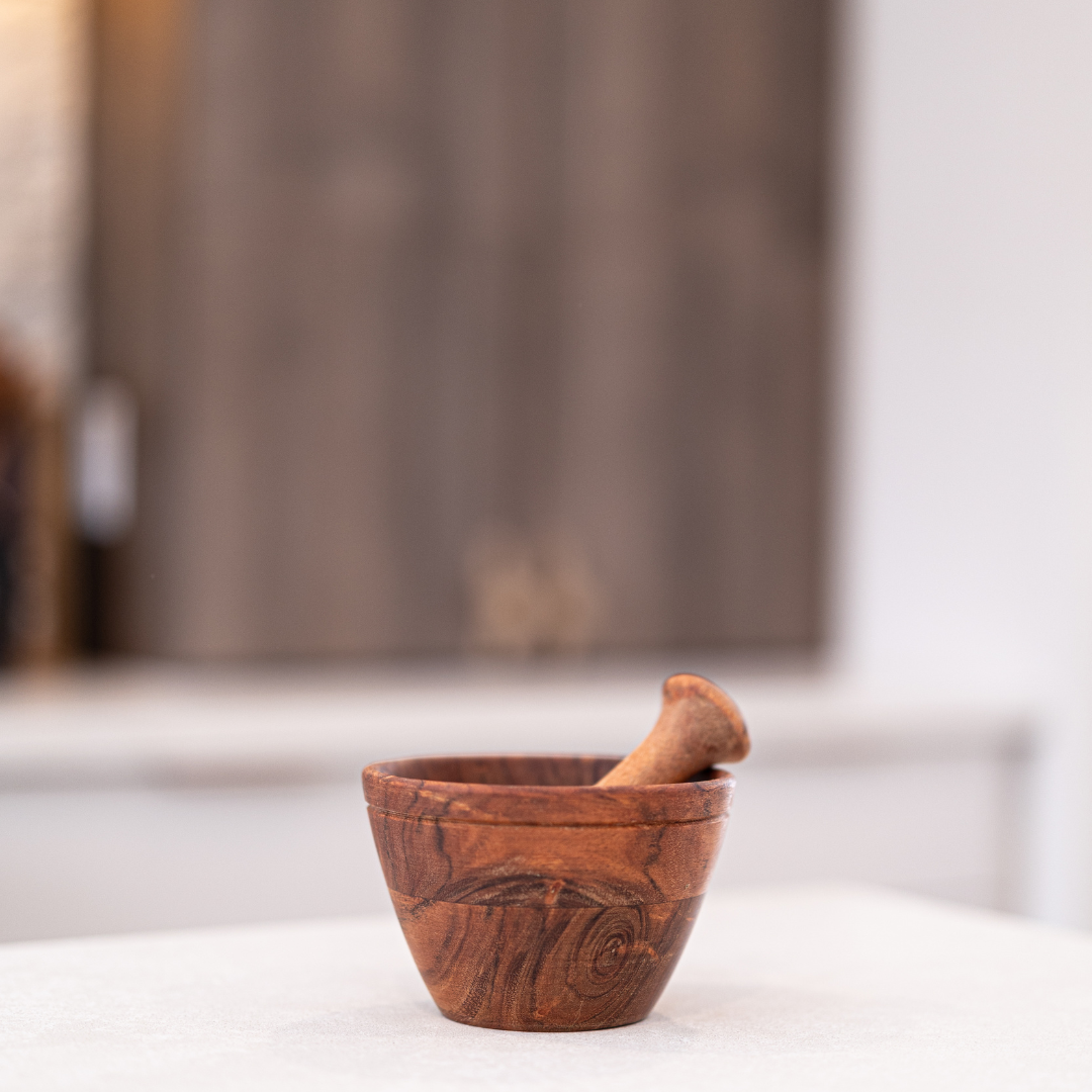Wooden mortar and pestle set by Luxe B Co, featuring smooth wood surface and sturdy design for grinding herbs and spices.