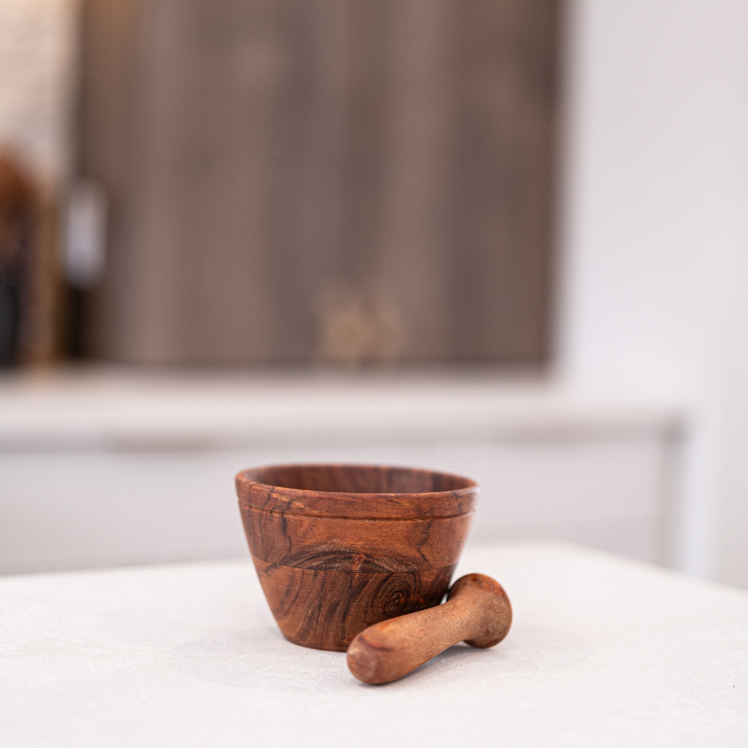 Wooden mortar and pestle by Luxe B Co, showing a smooth, round wooden bowl with pestle for grinding spices or herbs.